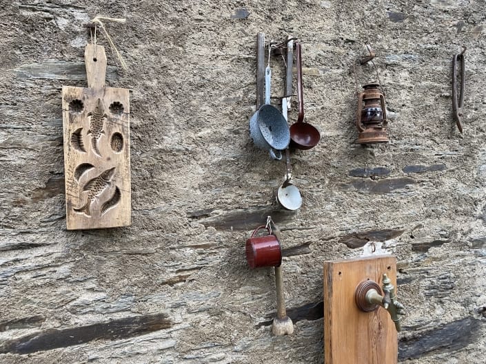 Alte Haushaltsgegenstände an Bruchsteinwand